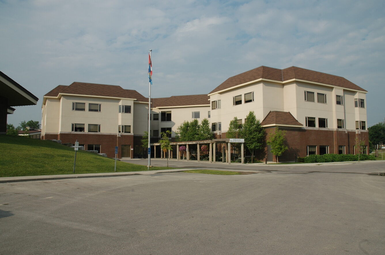 large three story brick building with covered entrance and large driveway