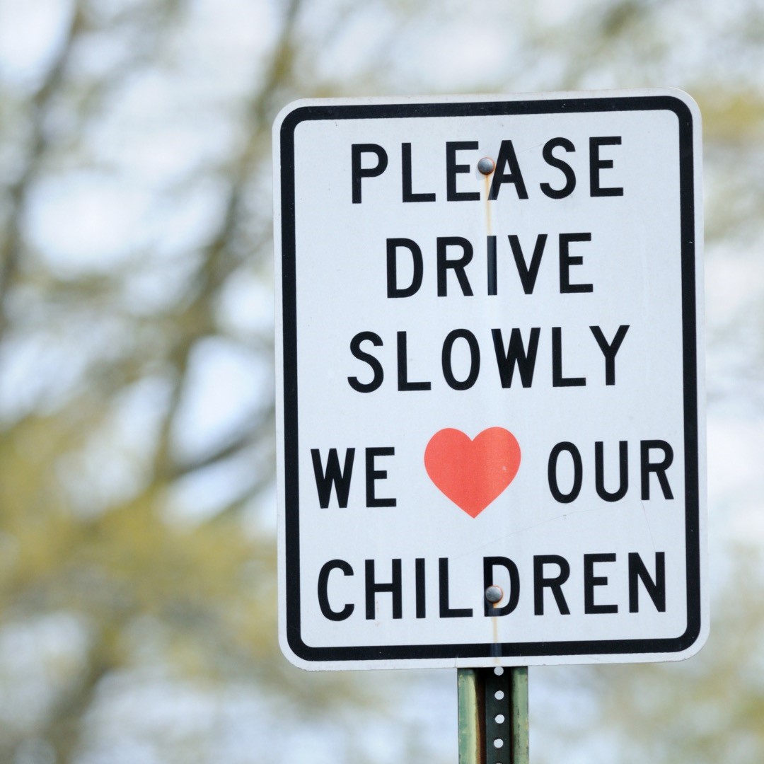 A traffic sign alerting motorists to "please drive slowly, we love our children"