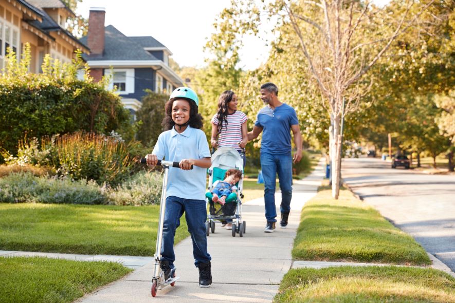 family walking down a sidewalk in a residential neighbourhood