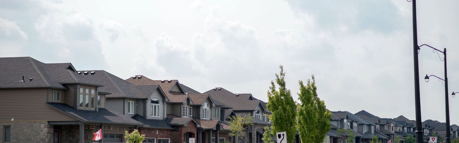 A row of residential homes with a blue sky with white clouds above.