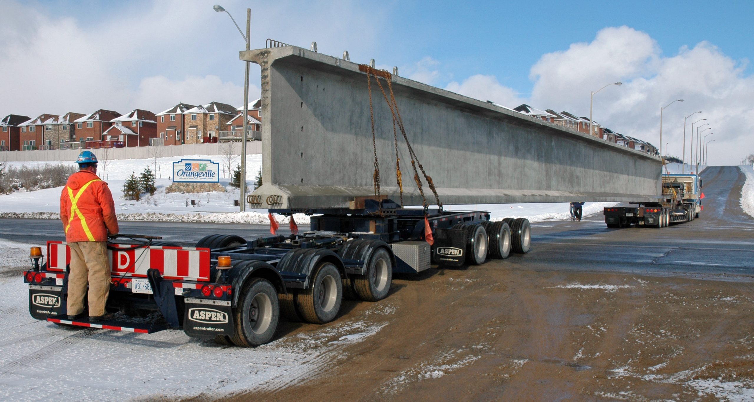 A girder is being delivered via an oversize load truck