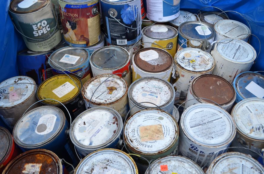 a large amount of paint cans sitting on a blue tarp