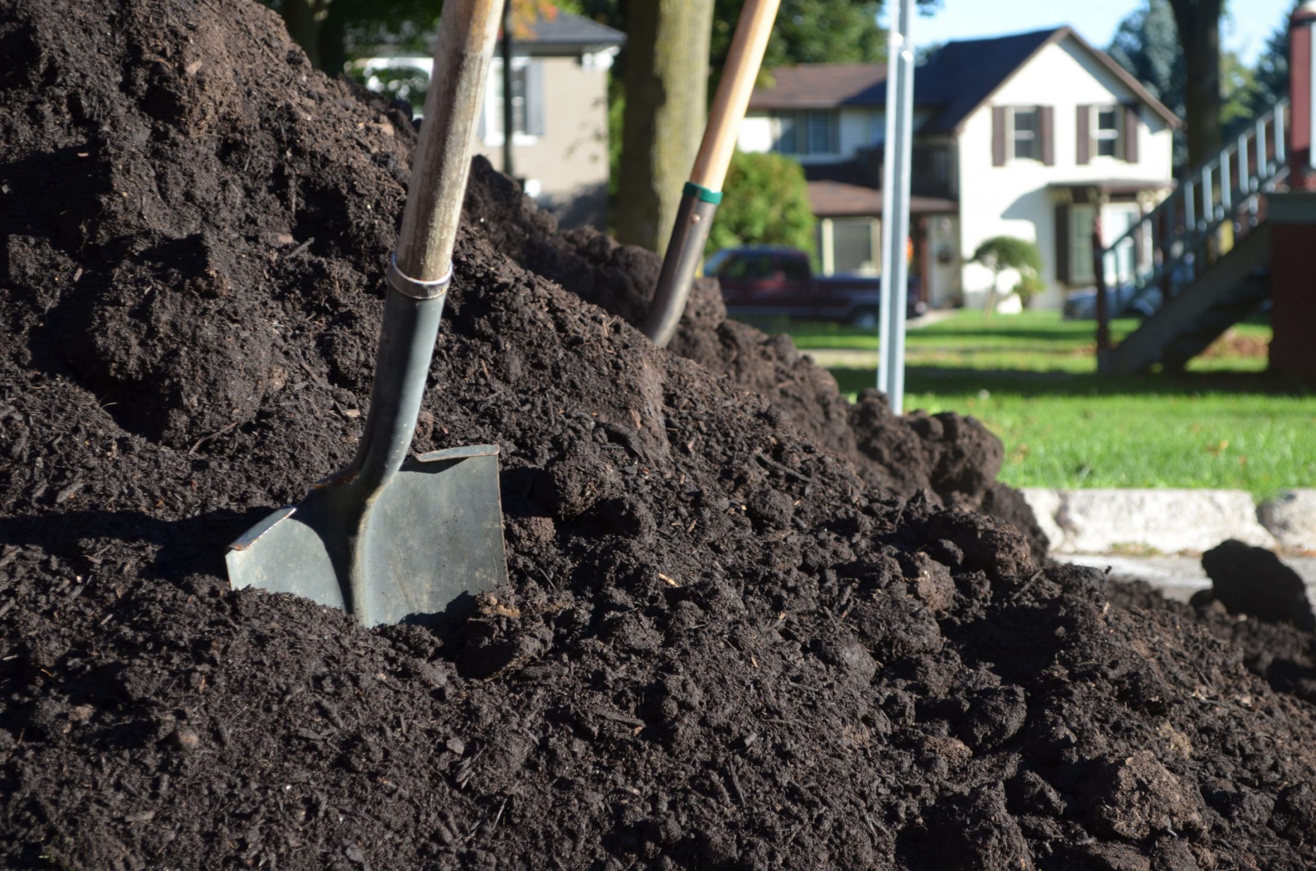 pile of compost with two shovels planted in it