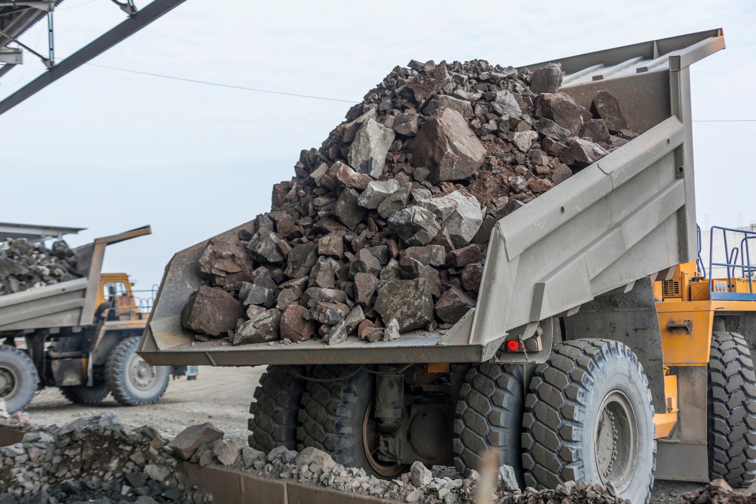 A truck is carrying a large load of rocks and boulders