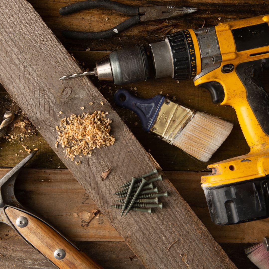 Tools including a drill, paintbrush, hammer and nails