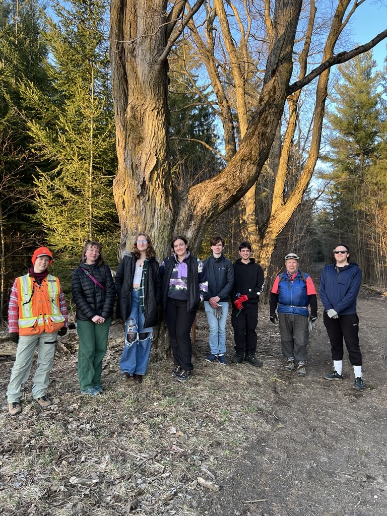 Youth climate ambassadors, County Forest staff, and WILD Outside program staff pose smiling at Invasive Species event at County Forest Main Tract