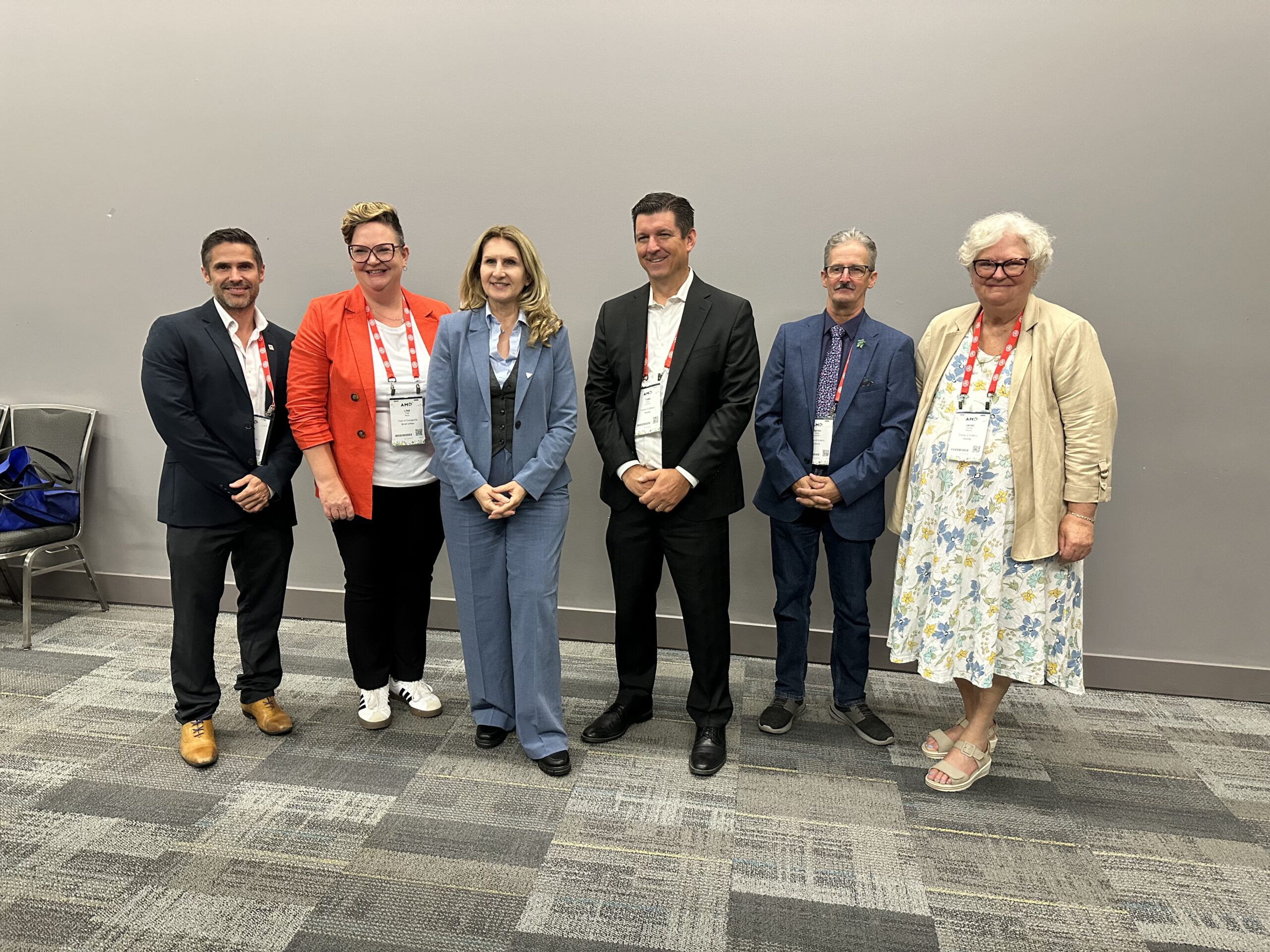 Dufferin County Councillors pose smiling in front of wall