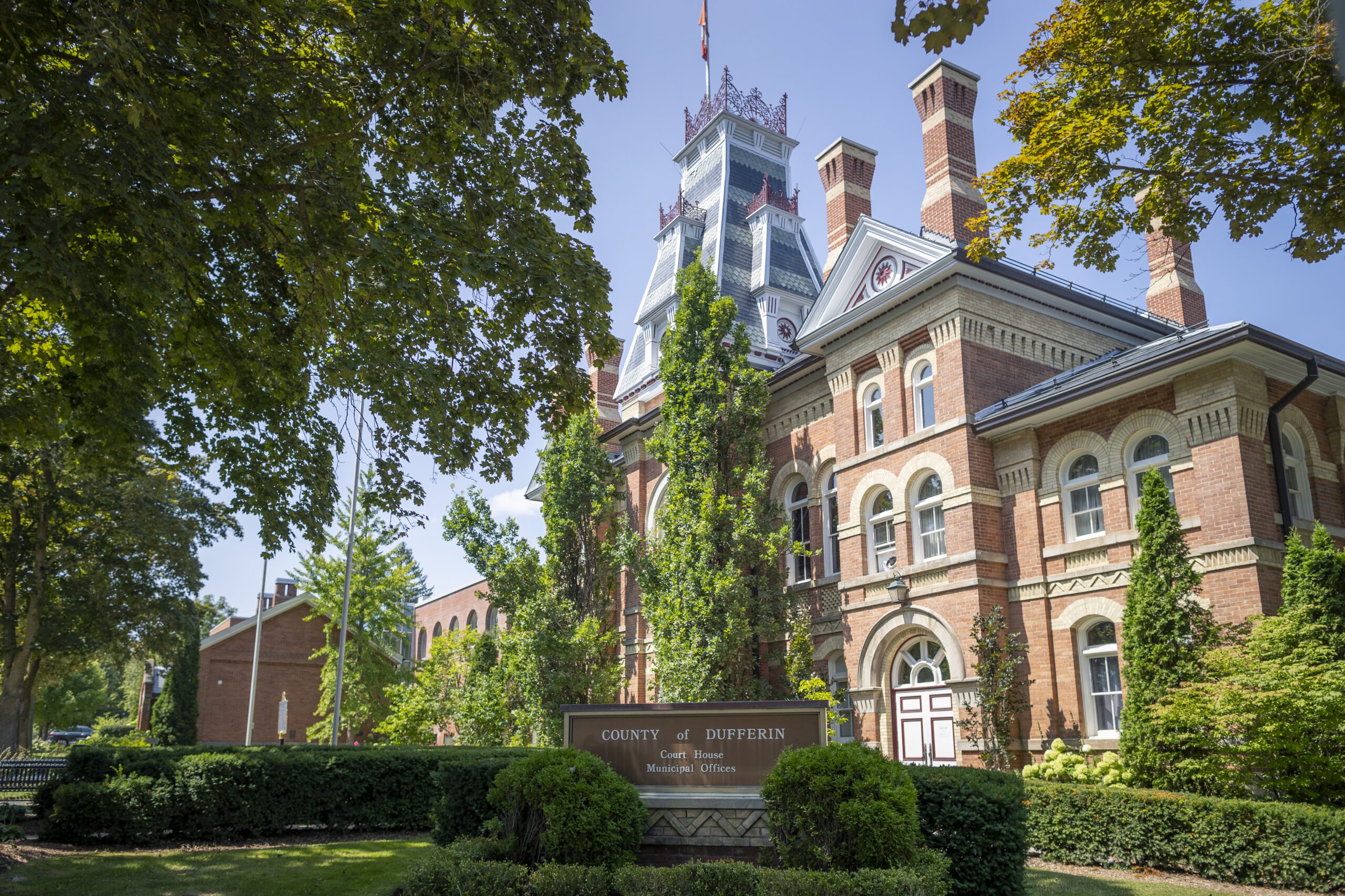 Front of courthouse on sunny day with trees.